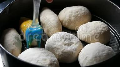 自制<strong>烘焙</strong>片上，一个女面包<strong>师</strong>用蛋黄将面团中的小球涂上油脂。 特别厨房